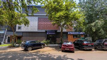 A building with a modern facade, a Physio Nautics sign, and several parked cars.