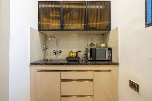Una cocina compacta con un fregadero, un microondas y una estufa.