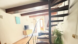Eine Wendeltreppe mit Holzvertäfelung, die zu einer oberen Etage führt.