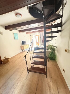 Una scala a chiocciola con finitura in legno che conduce a un piano superiore.