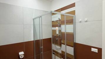 Un bagno moderno con doccia vetrata, un water e un lavandino.