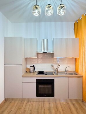 A modern kitchen with a built-in oven, a sink, and a coffee maker.