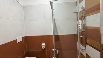 Ein modernes Badezimmer mit Duschkabine aus Glas, einem Bidet und einer Toilette.