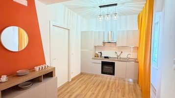 A modern kitchen with white cabinets, a wooden countertop, and a built-in oven.
