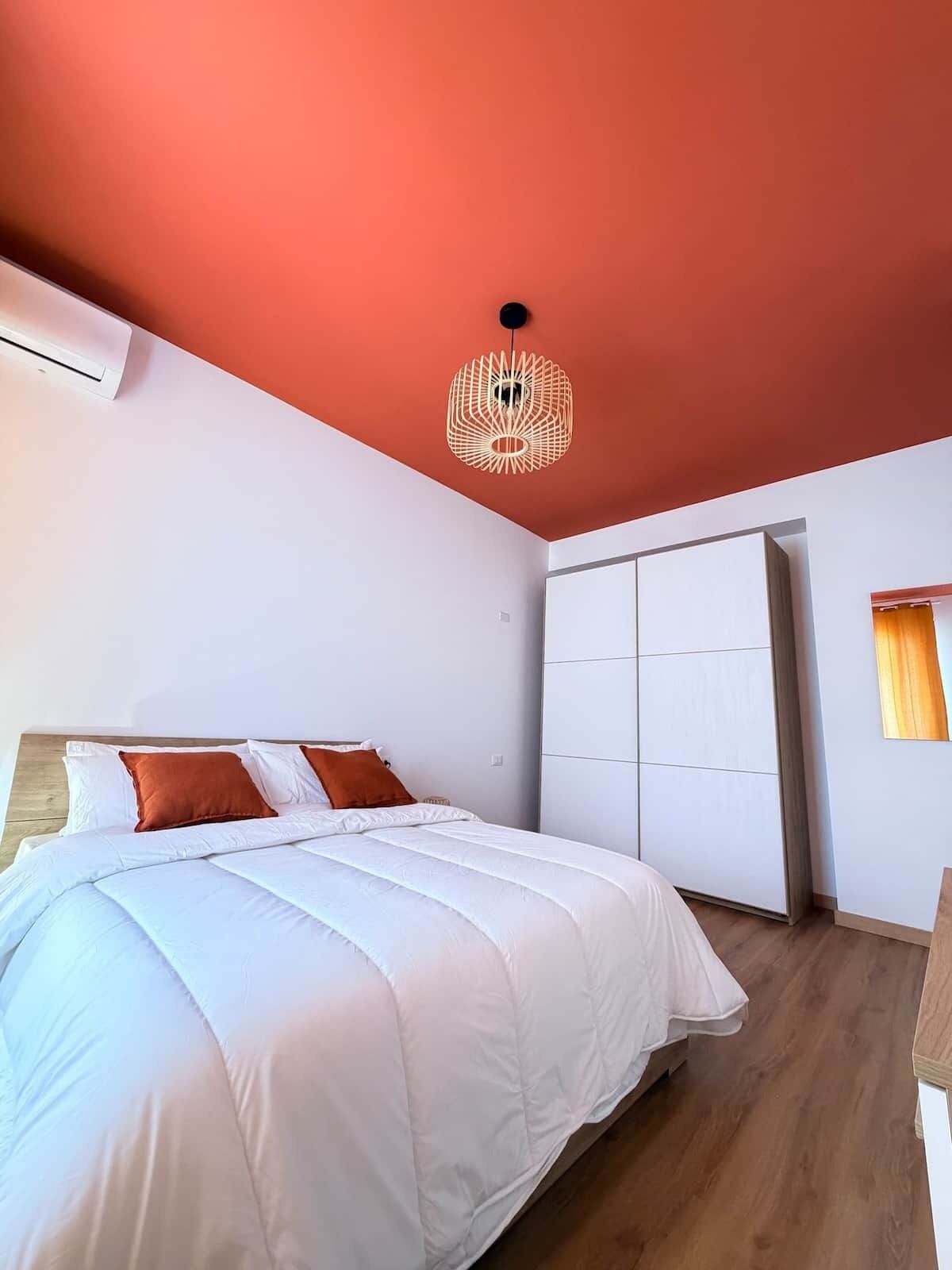 Ein Schlafzimmer mit einem Bett, einem Kleiderschrank und einer Deckenleuchte.