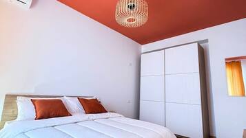 Ein Schlafzimmer mit einem Bett, einem Kleiderschrank und einer Deckenleuchte.