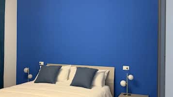Un dormitorio con una cama, mesitas de noche y una lámpara moderna.