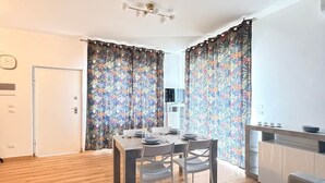 Un espace de vie moderne comprenant un coin repas, un canapé et une kitchenette.