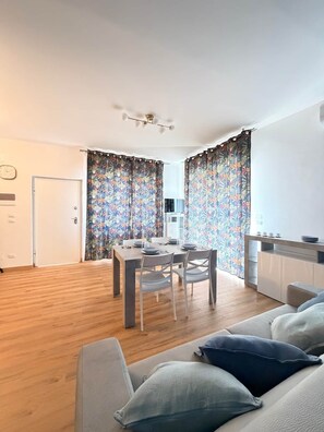 Un espacio moderno de estar con comedor, sofá y kitchenette.