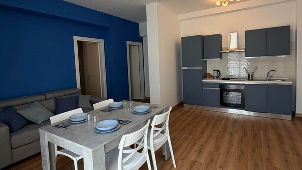 Un appartement moderne comprenant un coin repas, une cuisine et un espace de vie.