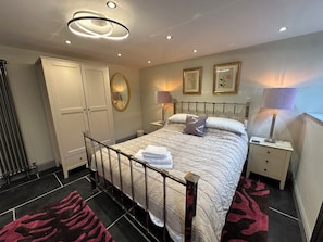 A hotel room with a bed, bedside tables, a wardrobe, a mirror, and a ceiling light fixture. - La'al Kirkstone Brow (Ambleside)