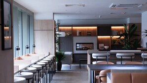 A modern interior with a long bar area, seating, and a kitchen visible in the background. - Student Only Centre Court (Nottingham)