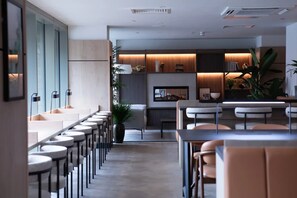 A modern interior with a long bar area, seating, and a kitchen visible in the background. - Student Only Centre Court (Nottingham)