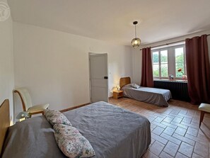 A room with two beds, a window with curtains, a radiator, and a door. - Spacious house in the heart of the Loire - 15 guests (Pouilly-sous-Charlieu)