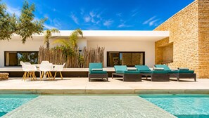 A modern outdoor pool area with lounge chairs and a dining set. - NAUSIKAA: 4-bedroom villa with concierge, 420 m² in Essaouira, with a 20-meter pool. (Essaouira)