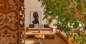 A modern living room with a sofa, coffee table, and a painting on the wall. - NAUSIKAA: 4-bedroom villa with concierge, 420 m² in Essaouira, with a 20-meter pool. (Essaouira)