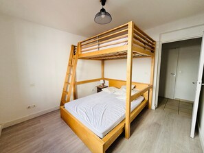 A bunk bed with a ladder, a bedside table, and a door to a closet. - Apartment with AC, parking - 6 guests (Argelès-sur-Mer)