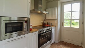 Una cocina con horno empotrado, microondas y estufa.