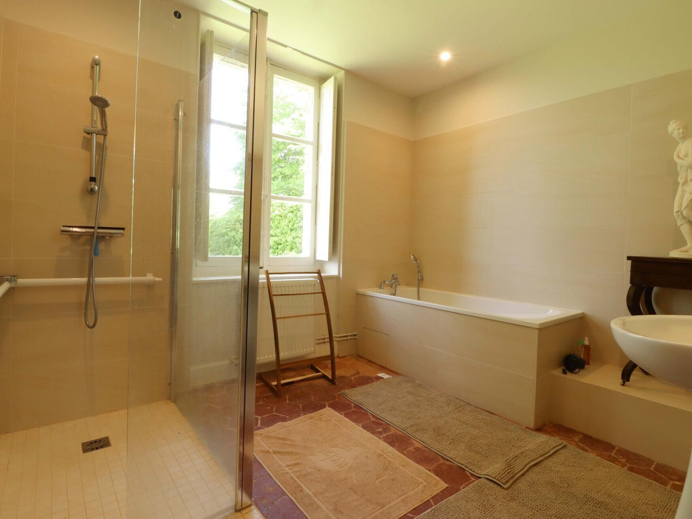 Un baño con ducha, bañera, inodoro y ventana.