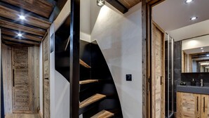 Een modern interieur met een houten trap, een keuken en uitzicht op het buiten.