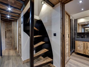 A modern interior with a wooden staircase, a kitchen area, and a view of the outside. - Renovated apartment in Val-d'Isère - 4 guests (Val-d'Isère)