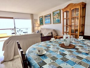 A room with a bed, a table set for tea, a wooden cabinet, and a balcony with a view. - Seafront apartment, pets - 6 guests (Tossa de Mar)