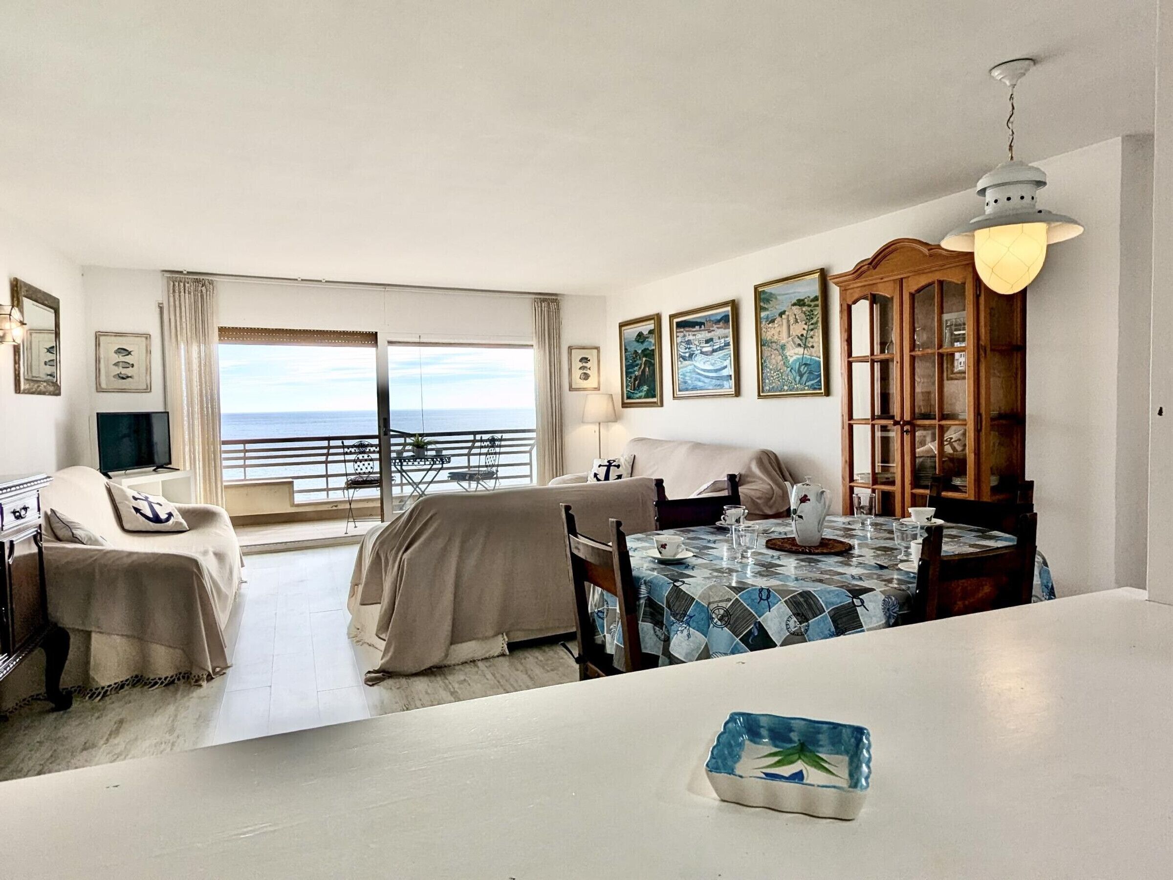 Une chambre avec un balcon, une table à manger et un buffet.
