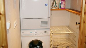 A compact laundry area with a front-loading washing machine and a stacked dryer. - Family apartment in center, mountain view - 4 guests (Val-d'Isère)