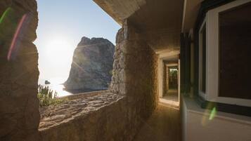 A stone interior with a view of the sea through a window.