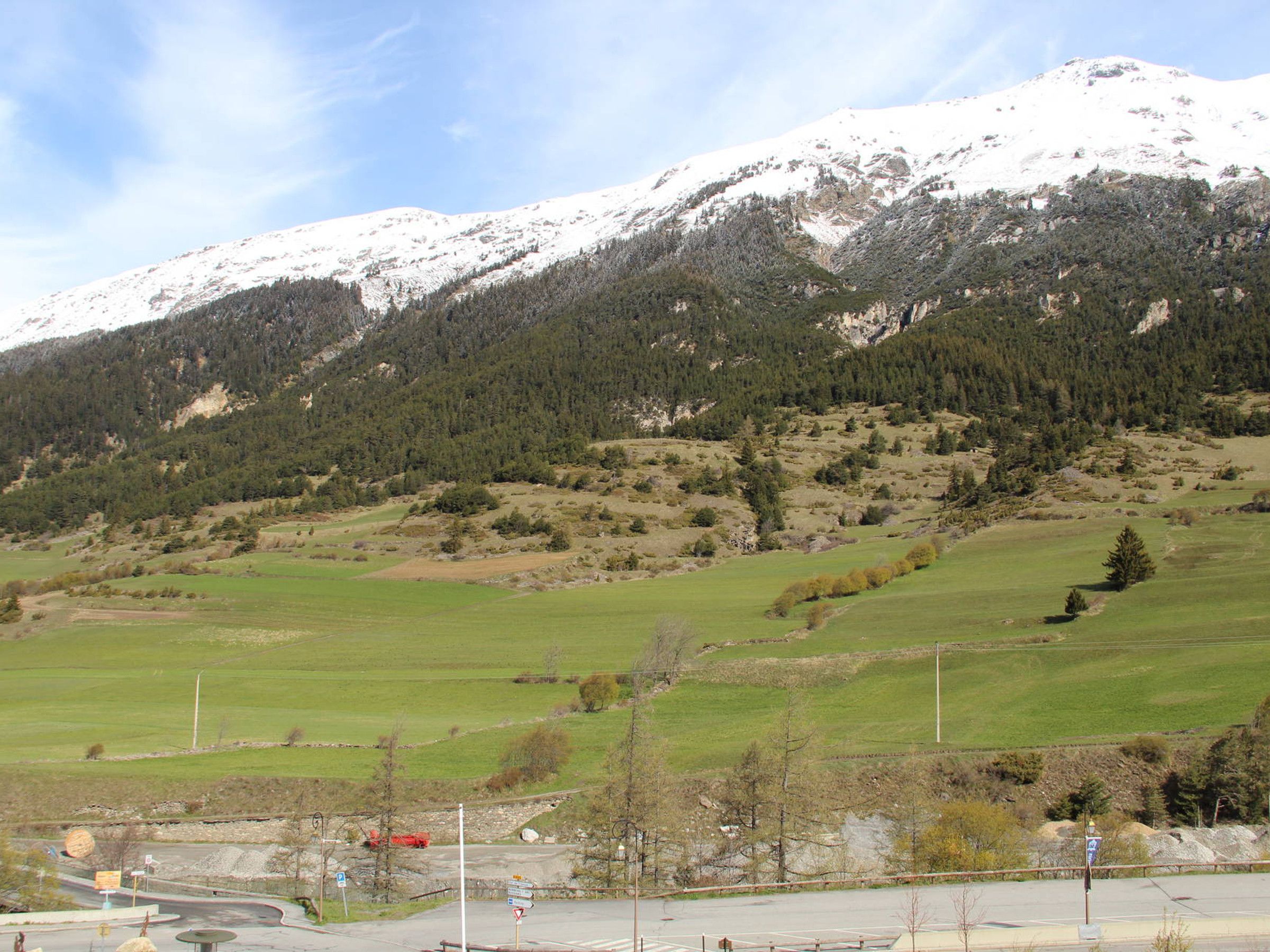 A mountainous landscape with a road leading to a parking area.
