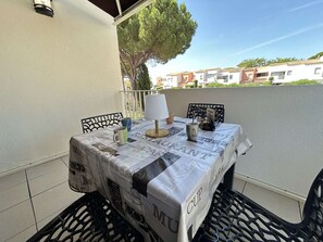 Ein Tisch im Freien mit Tischdecke, Lampe und Tasse auf einem Balkon.
