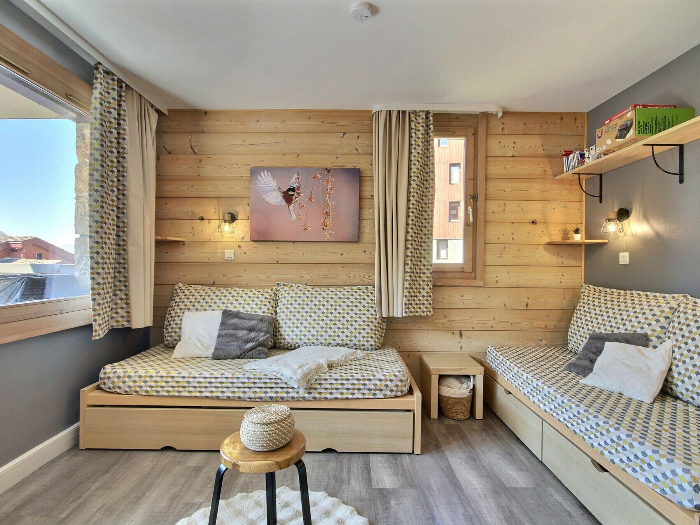 Une pièce chaleureuse avec un mur en bois, un lit, un canapé, une petite table et une décoration murale.