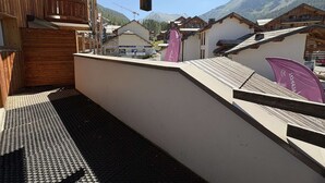 Ein Balkon mit Blick auf Berge und einen Skiort im Hintergrund.