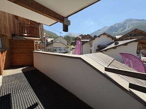 A balcony with a view of mountains and a ski resort in the background. - Ski-in/ski-out apartment - 8 guests (Les Orres)