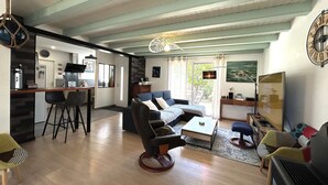 Ein modernes Wohnzimmer mit Sofa, Couchtisch und einem Essbereich mit Stühlen.