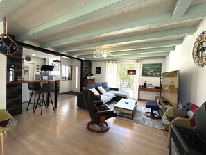Ein modernes Wohnzimmer mit Sofa, Couchtisch und einem Essbereich mit Stühlen.