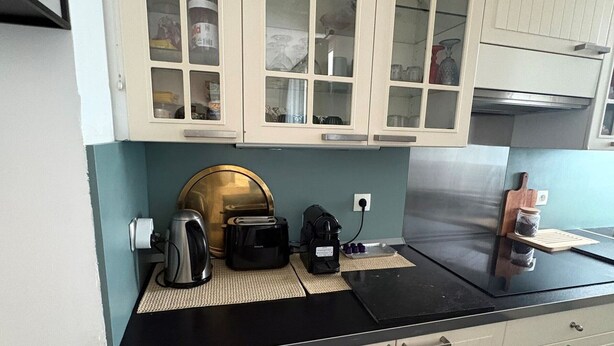 A kitchen with a black countertop, a coffee maker, a toaster, and a kettle. - Stunning T2 AC, sea view - 4 guests (Sète)