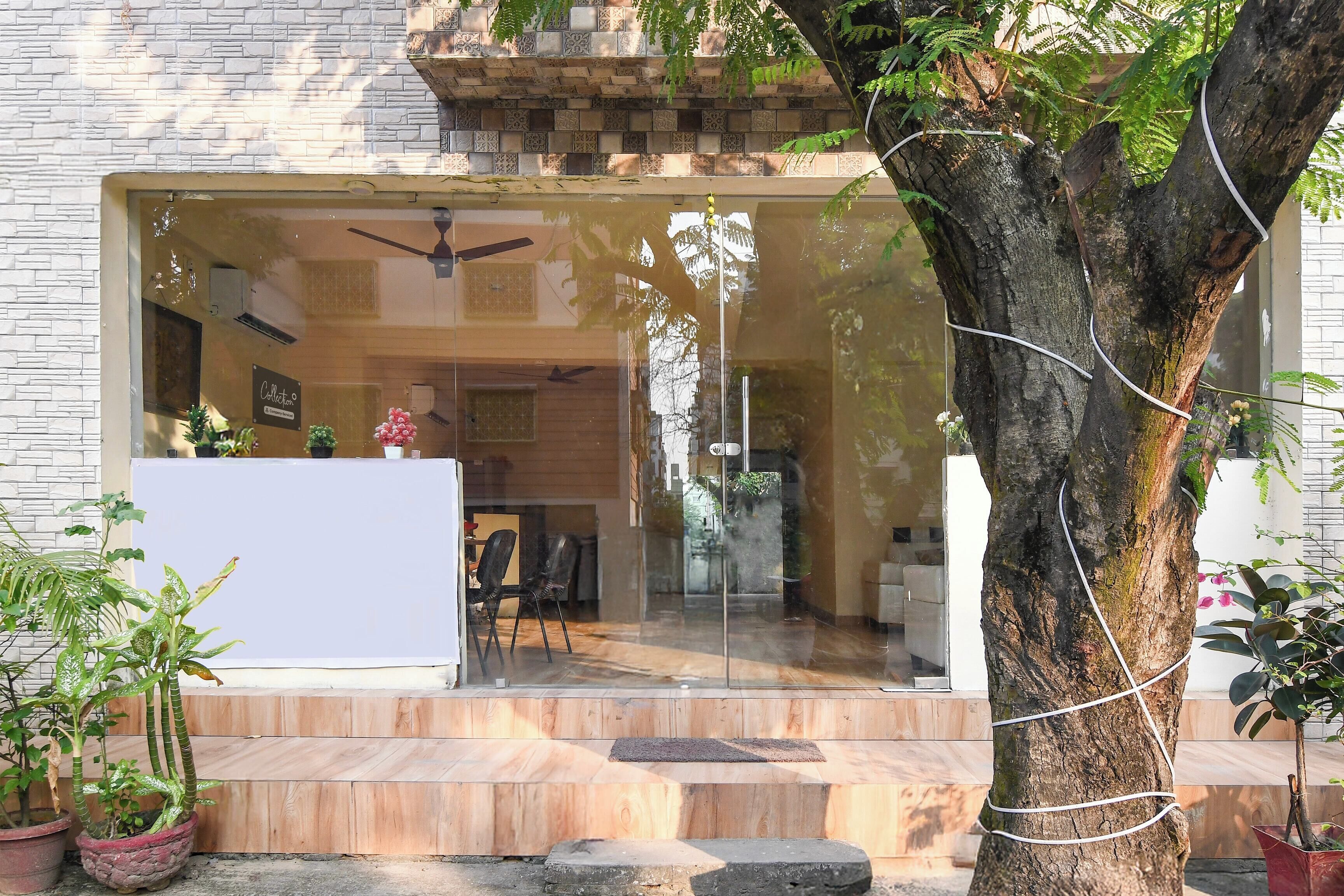 A modern building with a glass entrance, a ceiling fan, and a stone wall.