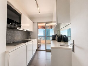 Eine moderne Küche mit großem Fenster, einem Flachbildfernseher und Blick auf die Stadtlandschaft.