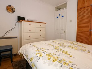 A bedroom with a bed, a dresser, a desk, and a wardrobe. - Aldena 12a South Snowdon Wharf (Porthmadog)