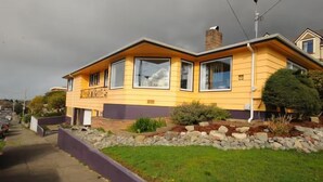 A two-story house with a flat roof, large windows, and a front yard with a rock garden and a small tree. - Sunset Studio, Best walkable location in Arcata & Bay View Studio (Arcata)