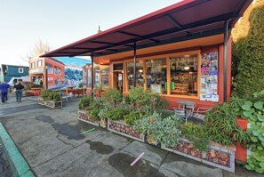 A restaurant with outdoor seating, a mountain mural, and a sign indicating it's open.