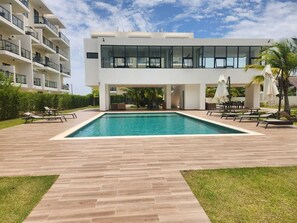 Un bâtiment moderne doté d’une piscine, d’un espace extérieur aménagé et d’un jardin bien entretenu.