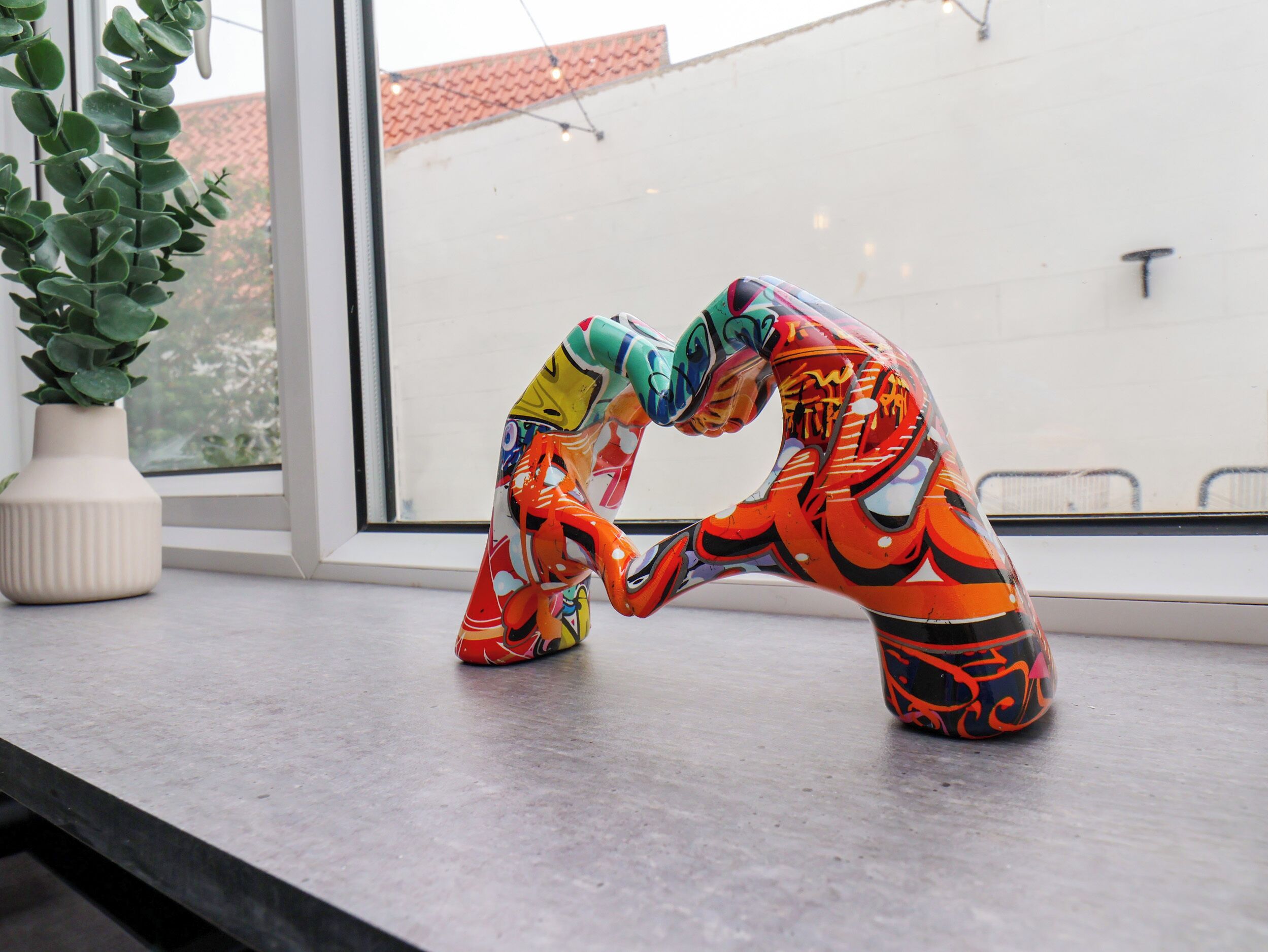 A pair of colorful, abstract sculptures on a windowsill.