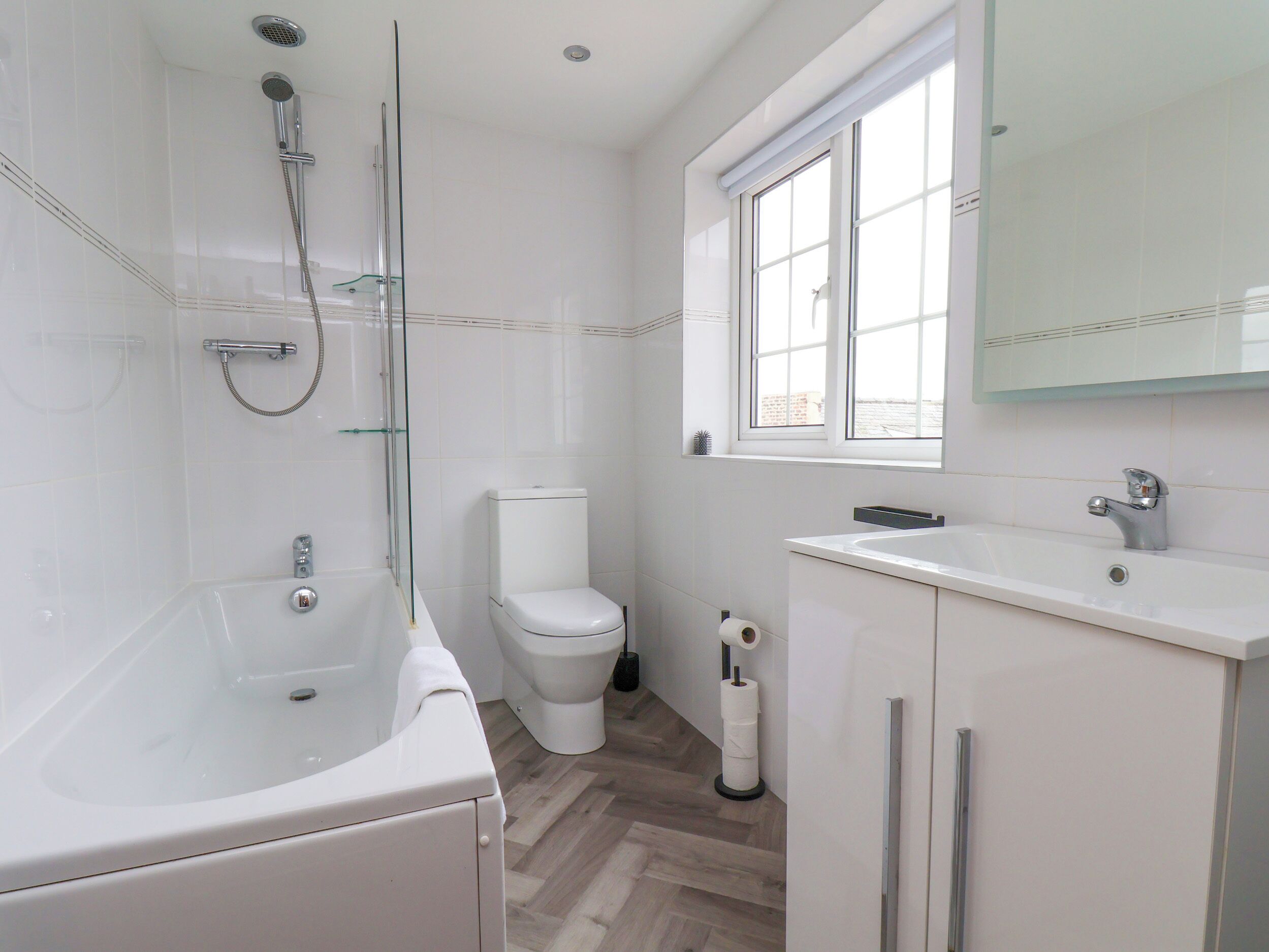 Ein modernes Badezimmer mit Badewanne, Toilette und Waschbecken.