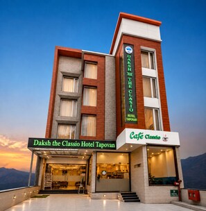 A hotel with a prominent sign for 'Daksh the Classio Hotel Tapovan' and a cafe named 'Cafe Classio' on the ground floor.