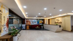 Zona de recepción de un hotel con diseño moderno, un mostrador de recepción y un mural en la pared.