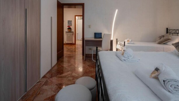 A hotel room with two beds, a desk, and a chair. - Charming Dorsoduro Venice Stay Near Art Museums and Canals (Venezia VE, Italy)