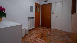 A hallway with a radiator, a wooden door, and a white cabinet. - Charming Dorsoduro Venice Stay Near Art Museums and Canals (Venezia VE, Italy)