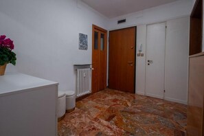 Ein Flur mit Heizkörper, Holztür und weißem Schrank.